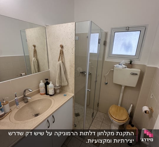 חדר אמבטיה עם מקלחון, כיור ושירותים